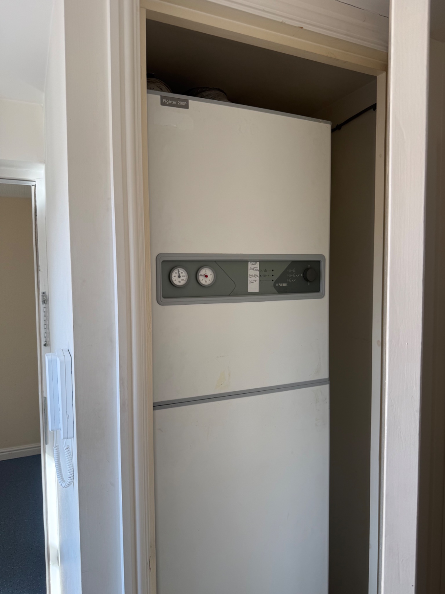 Existing air source heat pump unit in a cupboard before the gas conversion in Loughborough